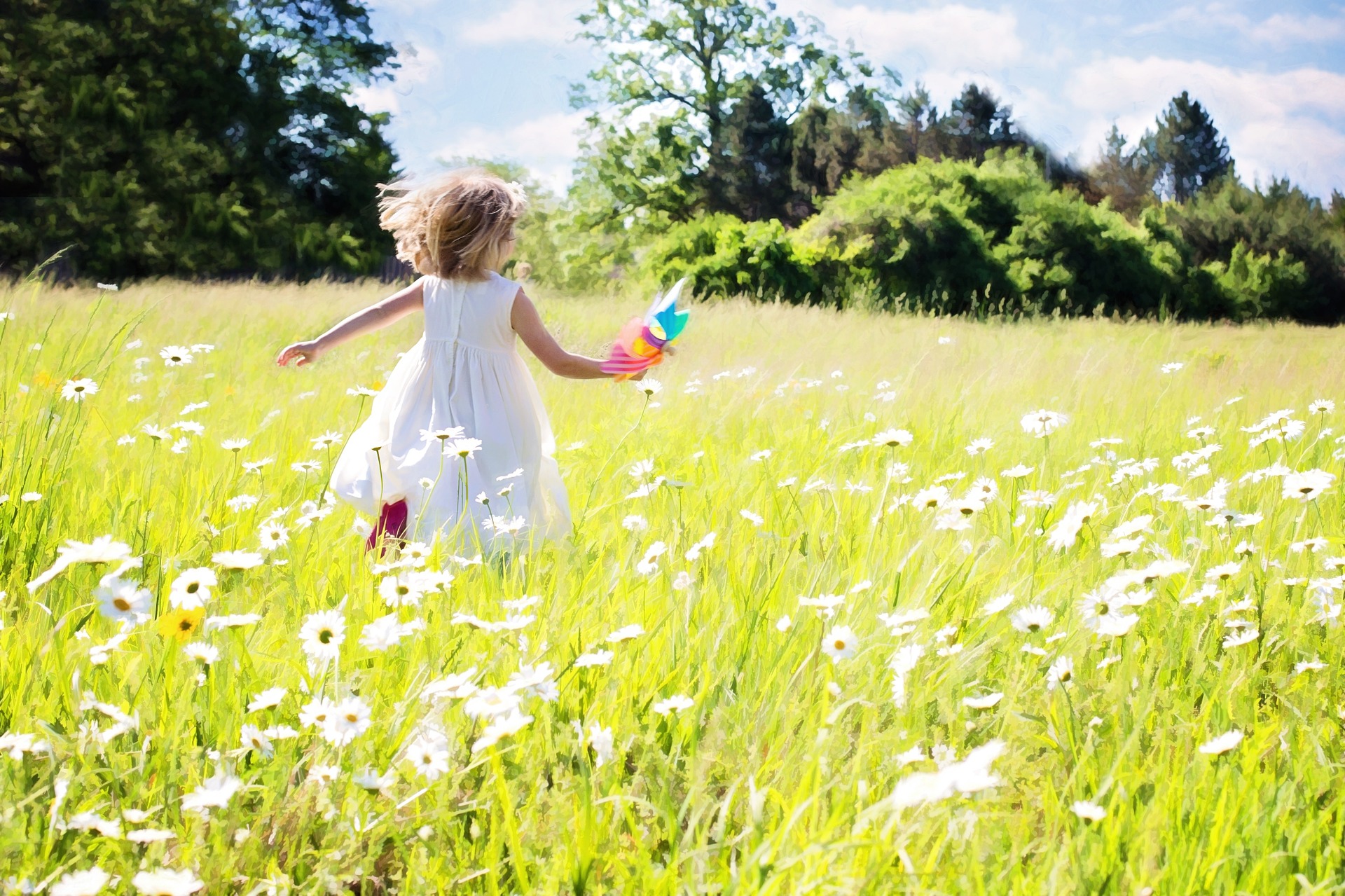 EIn Mädchen läuft über eine Blumenwiese 